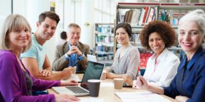 various smiling adults sit at a conference table