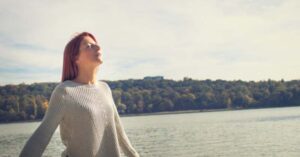 Woman breathing calmly in front of a lake