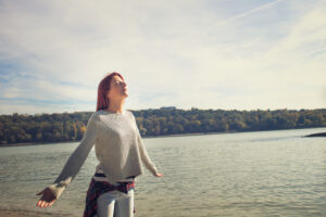 Woman breathing calmly in front of a lake