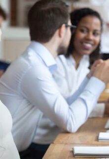 A woman smiling at her desk at work