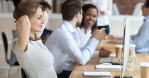 A woman smiling at her desk at work