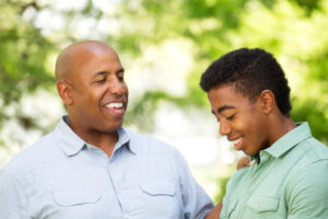 A father putting his hand on his son's shoullder