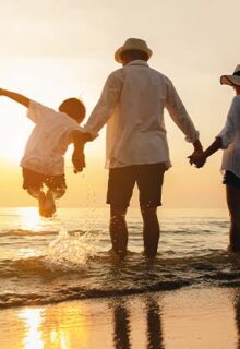 a family playing on the beach at sunset