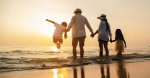 a family playing on the beach at sunset