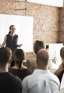 woman presenting to a room full of colleagues