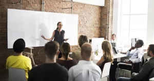 woman presenting to a room full of colleagues