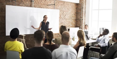 woman presenting to a room full of colleagues