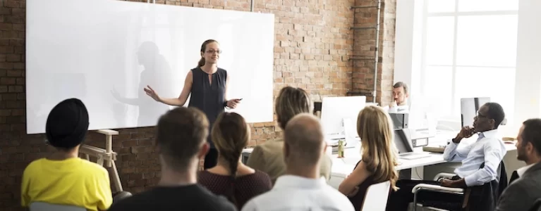 woman presenting to a room full of colleagues