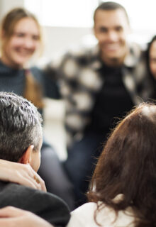 group of smiling people huddling in a circle