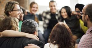 group of smiling people huddling in a circle