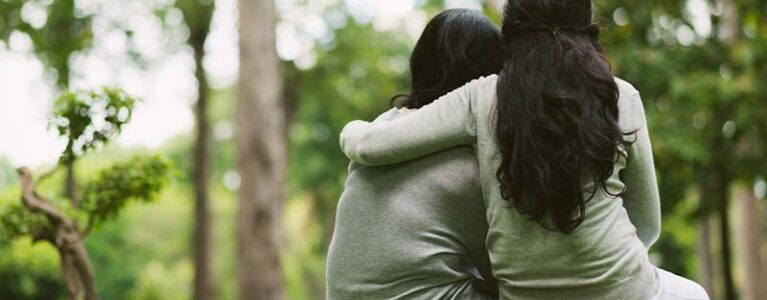 Girl hugging boy outside