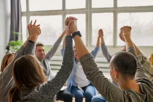 circle of people holding hands raised in the air