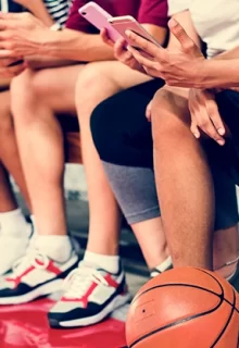 boys basketball team texting from the bench