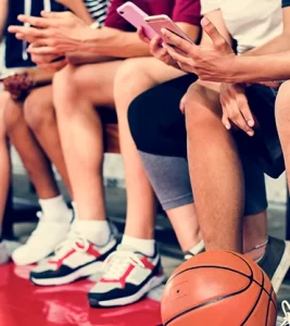 boys basketball team texting from the bench