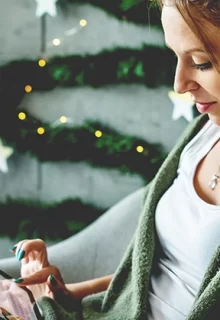 woman using an ipad in a room decorated for winter holidays