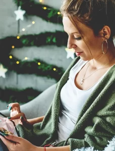 woman using an ipad in a room decorated for winter holidays