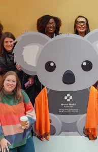 MHFA Summit attendees posing with ALGEE koala sculpture