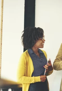 three smiling colleagues chat by a stairwell