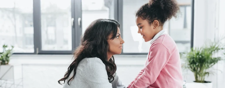 a mother and young daughter face each other