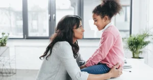 a mother and young daughter face each other