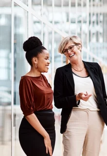 four women chat in an office setting