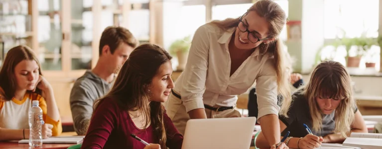 teacher works with students in a classroom