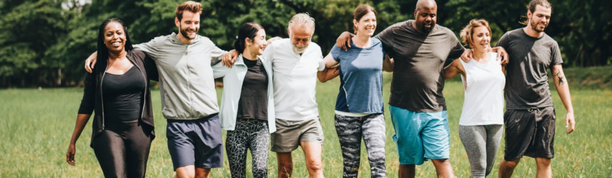 group of people walking outside with their arms linked