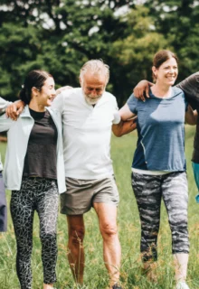 group of people walking outside with their arms linked