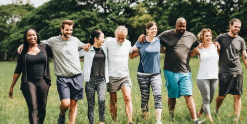 group of people walking outside with their arms linked