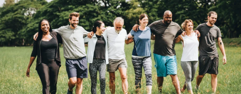 group of people walking outside with their arms linked