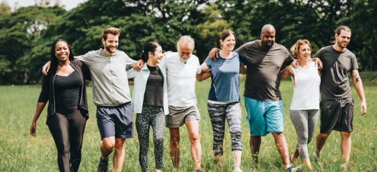 group of people walking outside with their arms linked