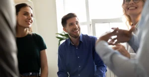 three smiling people look at a presenter