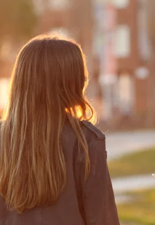 two young women walk outside on a path and talk