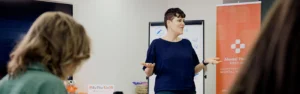 Mental Health First Aid Instructor stands in front of a class of students