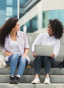 two college students sit together on steps