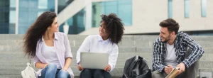 three college students sit together on steps