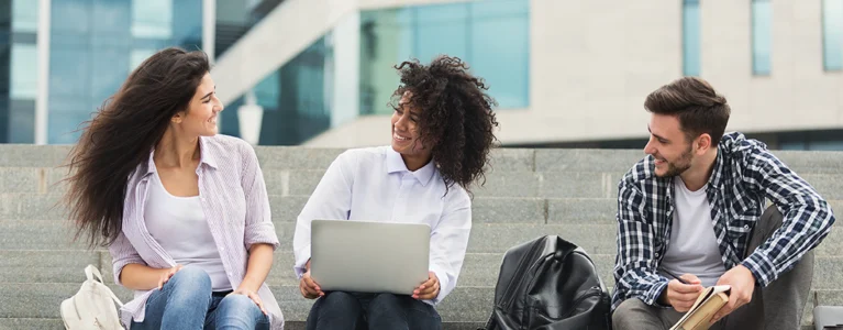 three college students sit together on steps