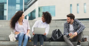 three college students sit together on steps