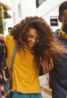 a group of teens walking with their arms around each other