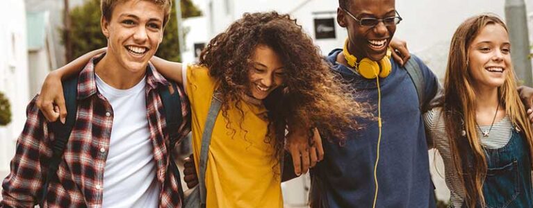 a group of teens walking with their arms around each other