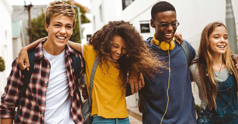 a group of teens walking with their arms around each other