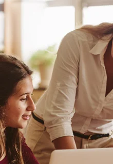 a smiling teacher helps students with their work