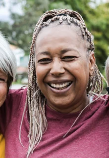 five smiling women stand together arm in arm