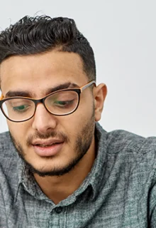 young man sitting on a couch talking to a counselor