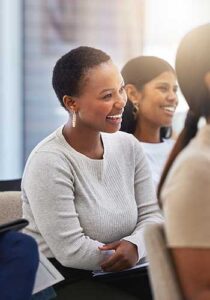 employees sit in a meeting smiling