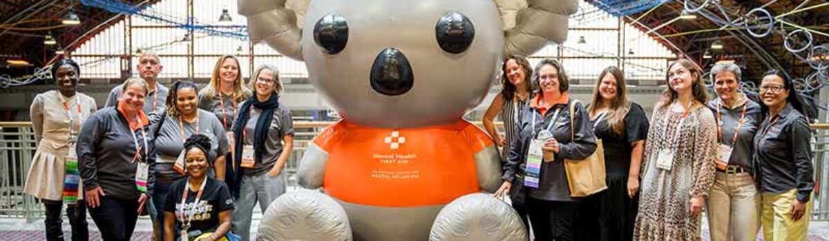 a group of people stand around a large inflatable bear