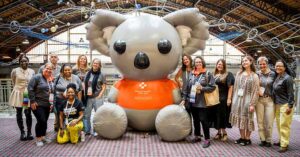 a group of people stand around a large inflatable bear