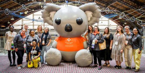 a group of people stand around a large inflatable bear