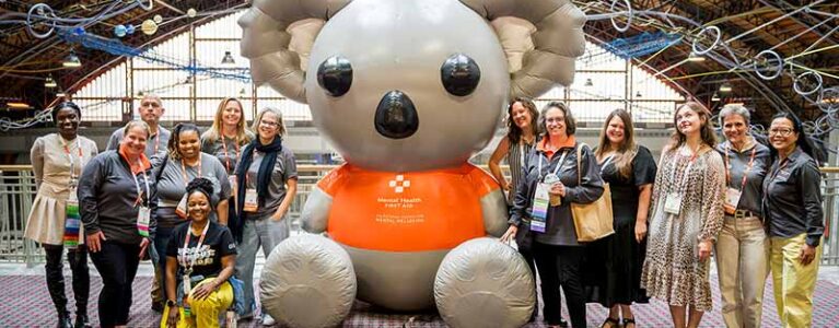 a group of people stand around a large inflatable bear