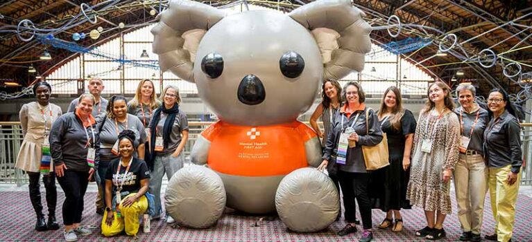 a group of people stand around a large inflatable bear